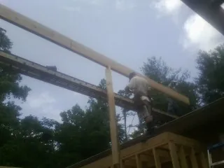 Carpenter setting a ridge beam over a new addition frame — Ice Dam Removal by Roofing Brothers in Mount Ephraim