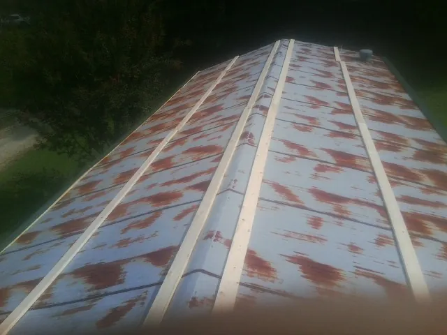 Rusted metal roof panels with new wood purlins before replacement — Storm Damage Roof Repair in Mount Ephraim by Roofing Brothers