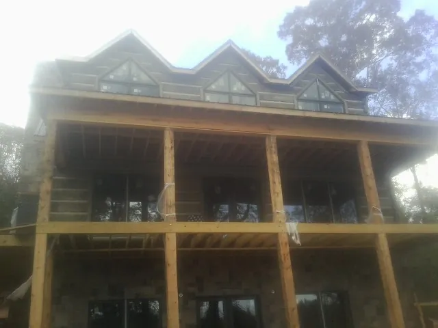 Dormers and porch framing on a large log home under construction — Roof Coating work by our crew in Mount Ephraim