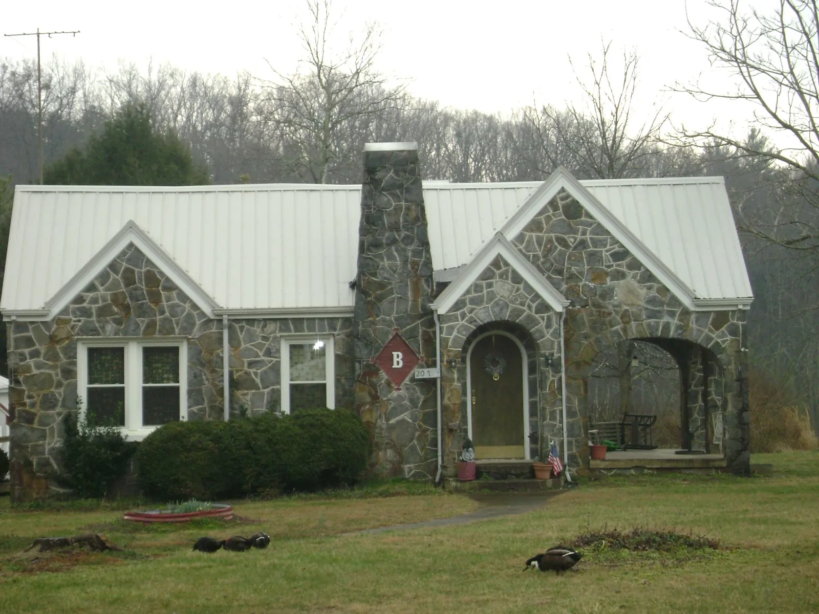 White metal roof on a stone cottage with steep gables in Mount Ephraim